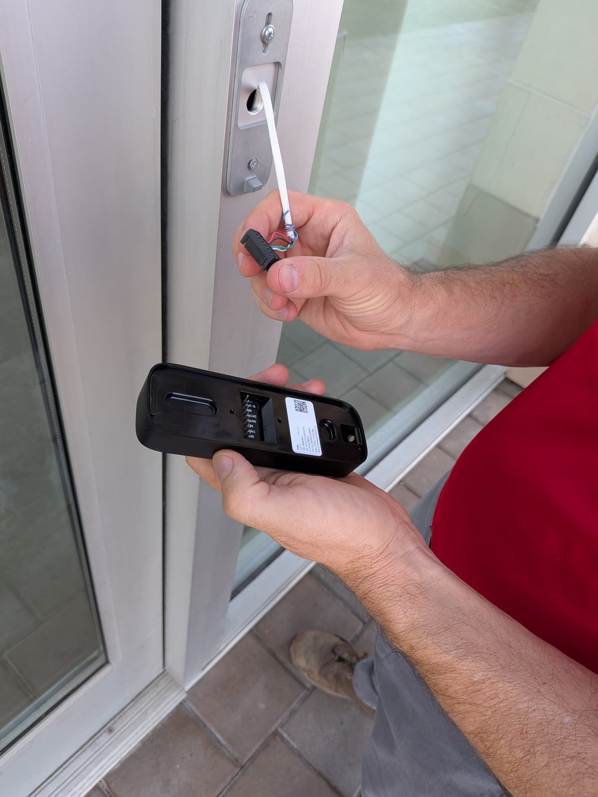 Technician swapping the front door reader for the keypad model