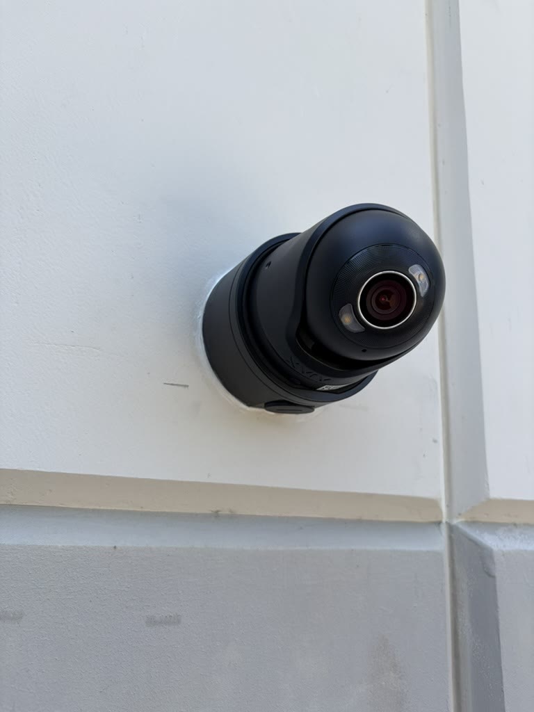 New turret security camera mounted on an exterior building wall