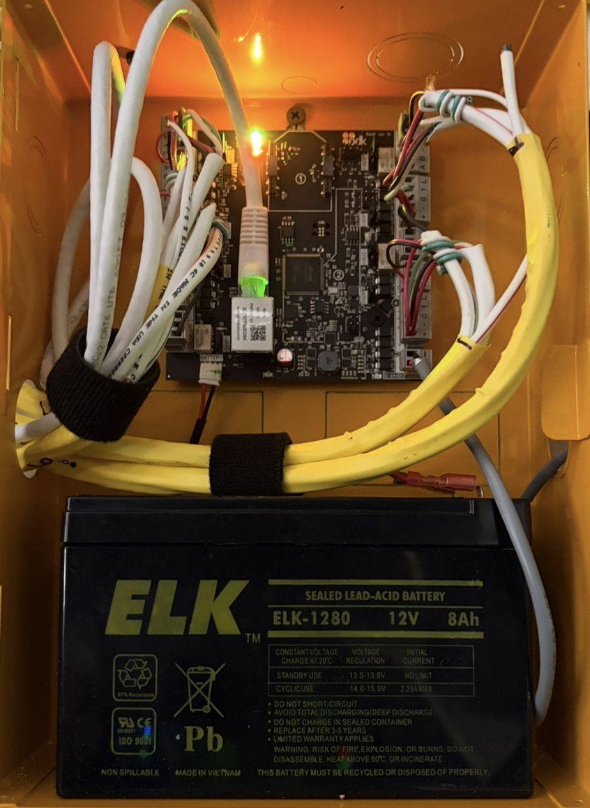 Neatly wired ProDataKey controller board and battery in a yellow enclosure